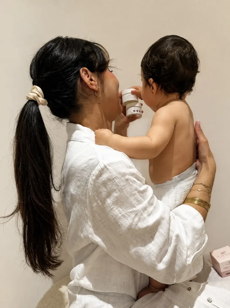 Maman en tenue blanche appliquant un soin sur le bras de son bébé
